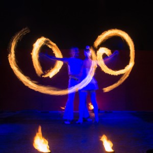 Feuerartisten Paar mit Flammenspiralen blau beleuchtet bei Feuershow