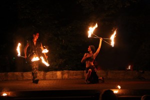 Feuertänzer Paar bei einer Feuertanztheater Feuershow mit Feuerstäben in dramatischer Pose