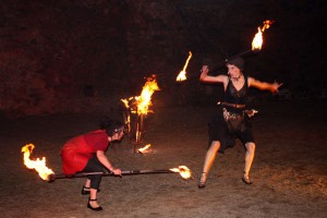 Dramatische Kampfszene mit Feuerstöcken bei einer Feuertanztheater Feuershow